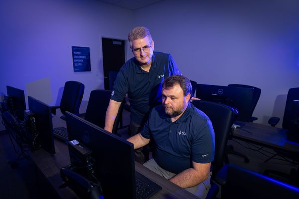 People in dark room working on computer.